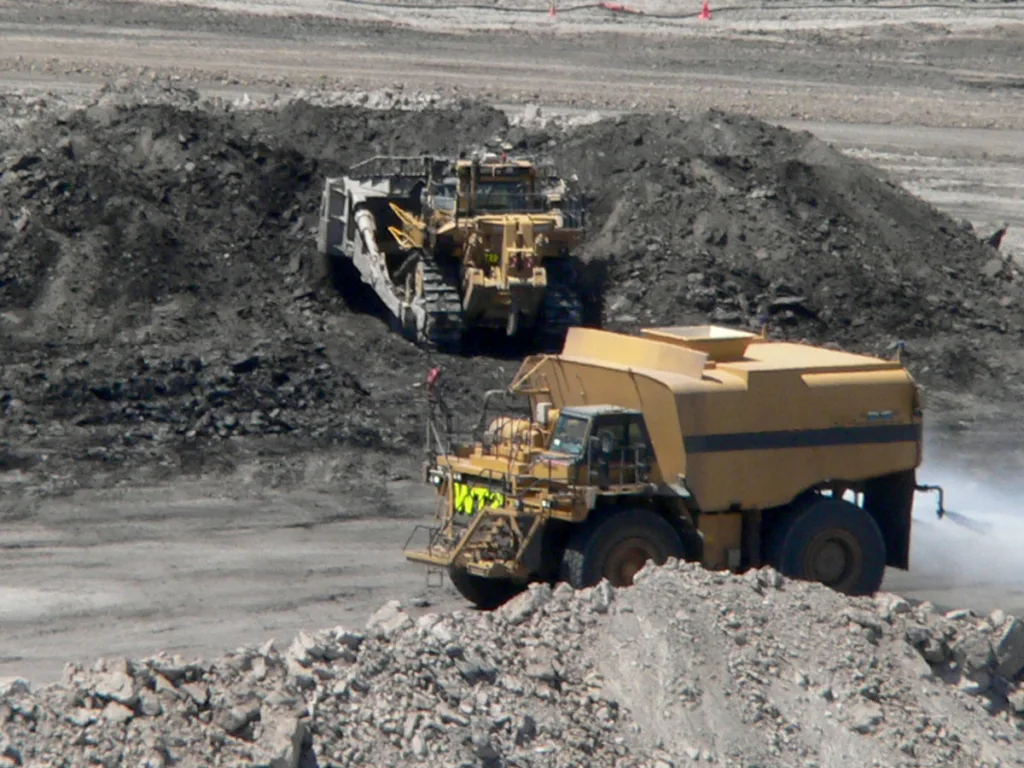 Photo of a bulldozer and a water truck working on a coal mine